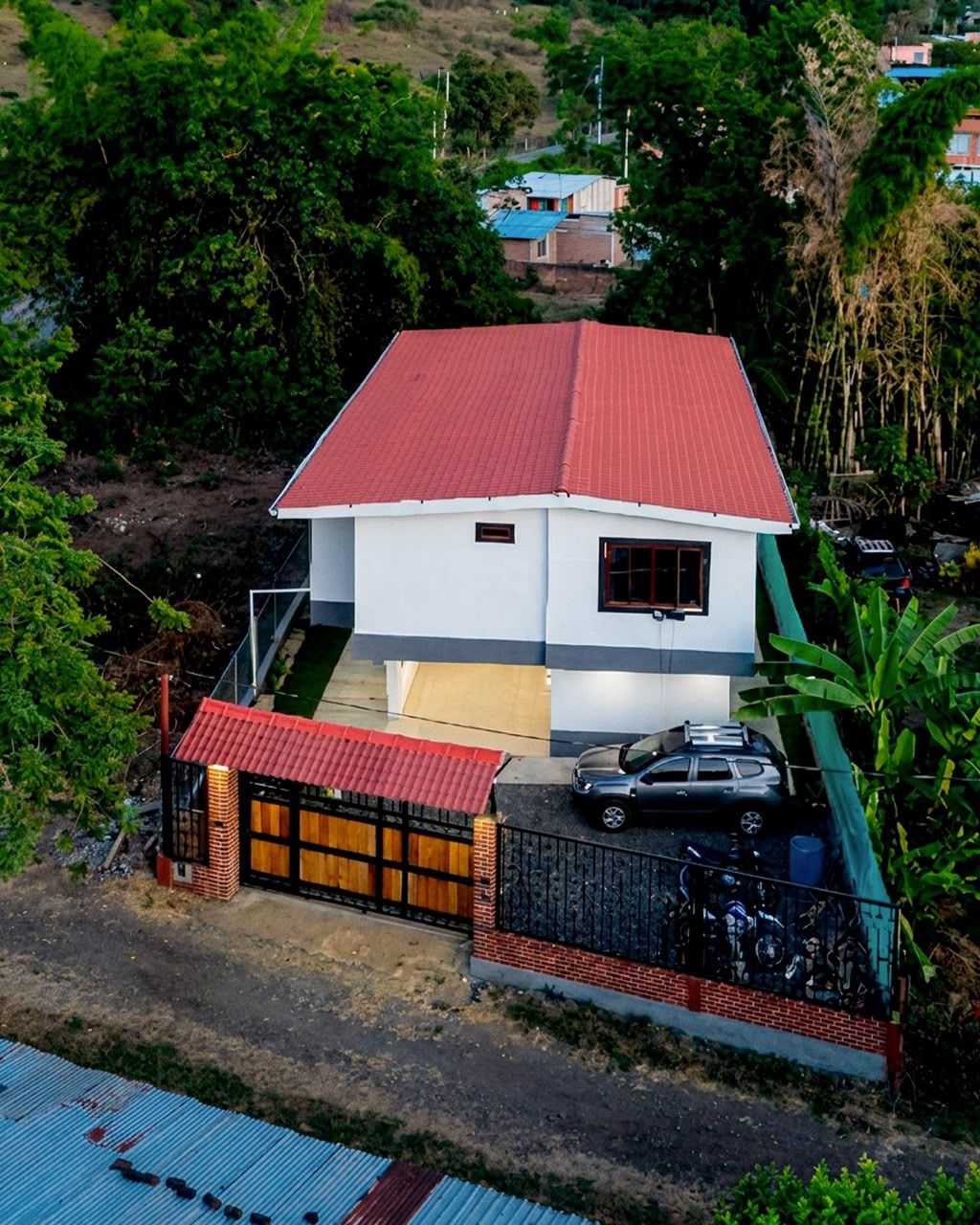 Entrada con portón de madera y parqueadero privado