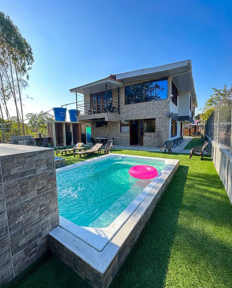 Piscina de Malak con jardín y la villa de dos plantas al fondo